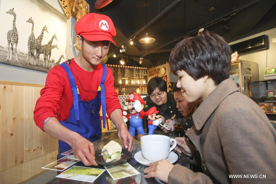 A waiter in the costume of Super Mario, a famous video game character, serves dishes at a Mario themed restaurant in Tianjin, north China, April 8, 2013. The restaurant that opened on Monday attracted many young customers due to its "Mario-like" waiters and various decorations. (Xinhua/Fu Wenchao)
