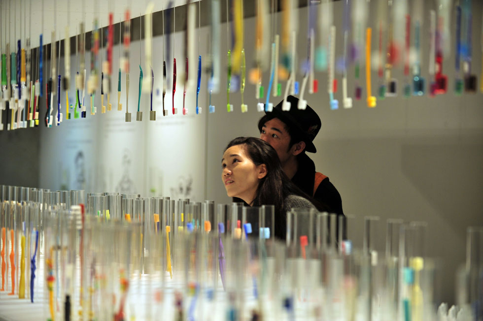 Visitors view various toothbrushes at a private exhibition from Wu Kwang-tyng, an associate professor of Tamkang University Department of Architecture, in Taipei, Taiwan, April 6, 2013. (Xinhua Photo/ Wu Jingteng)