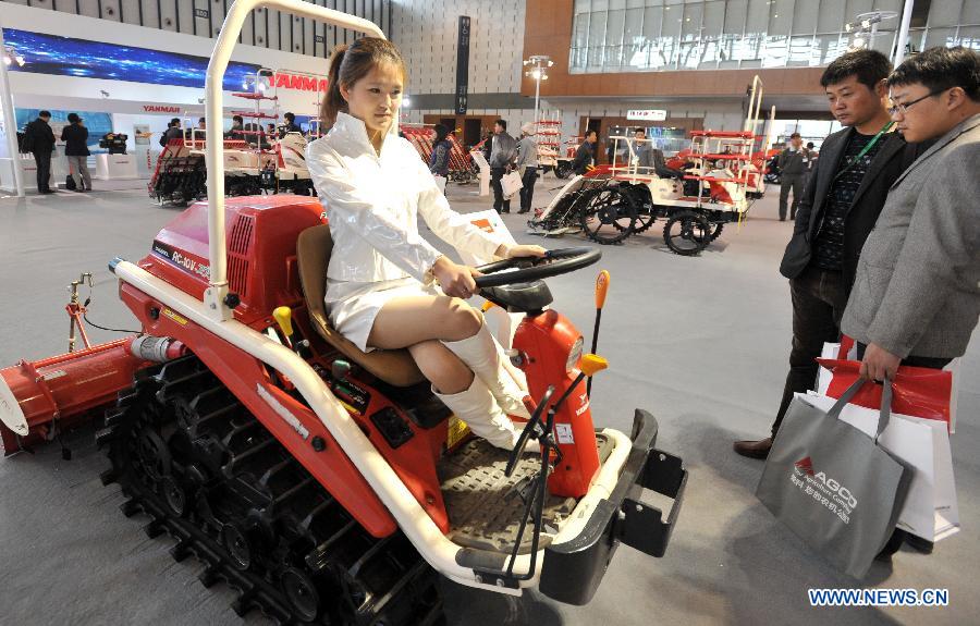 A model presents a machine at the 7th China Jiangsu International Agricultural Machinery Fair in Nanjing, capital of east China's Jiangsu Province, April 9, 2013. The three-day fair kicked off on Tuesday at Nanjing International Expo Centre. (Xinhua) 