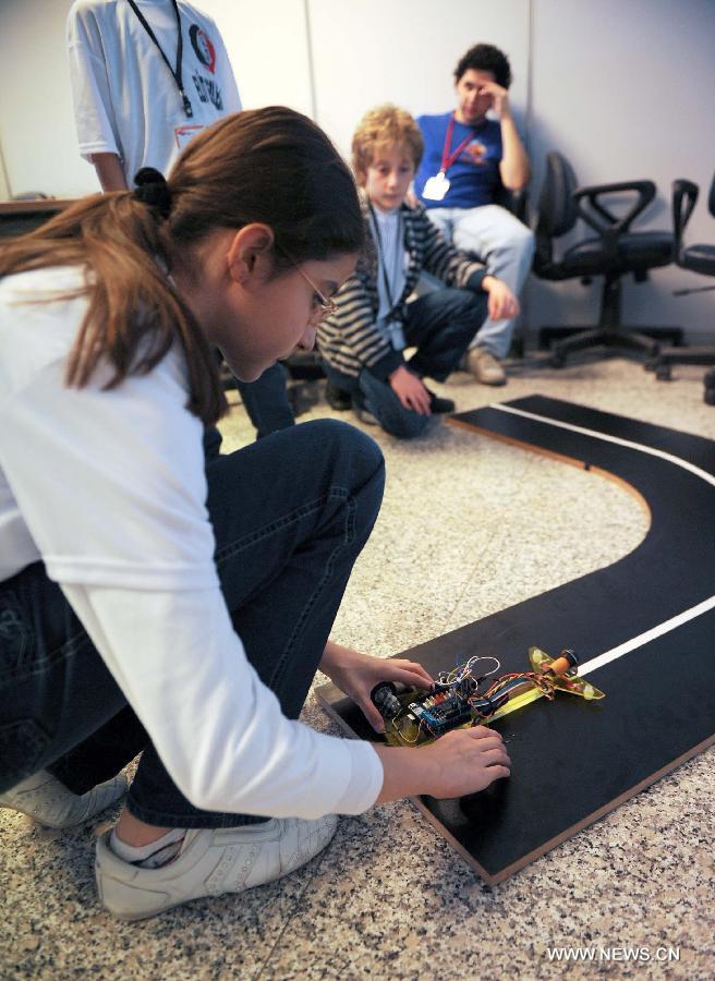A student adjusts her robot car in Istanbul, Turkey, April 11, 2013. The three-day Istanbul Technical University Robot Olympics was held in Demirel cultural center of Istanbul Technical University on Thursday. More than 100 teams from universities and high schools in Turkey participated in competitions and other activities. (Xinhua/Lu Zhe) 