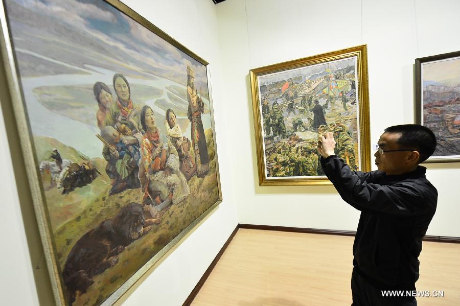 A visitor takes pictures of paintings at an exhibition commemorating the third anniversary of the Yushu earthquake, at the Qinghai Provincial Museum in Xining, capital of northwest China's Qinghai Province, April 14, 2013. A 7.1-magnitude earthquake hit Yushu on April 14, 2010, leaving 2,698 dead and over 12,000 injured.(Xinhua/Wu Gang) 