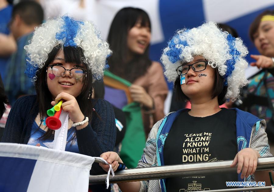 Fans of Lotus driver Kimi Raikkonen react during the drivers parade prior to the start of the Chinese F1 Grand Prix at the Shanghai International circuit, in Shanghai, east China, on April 14, 2013. (Xinhua/Li Ming)
