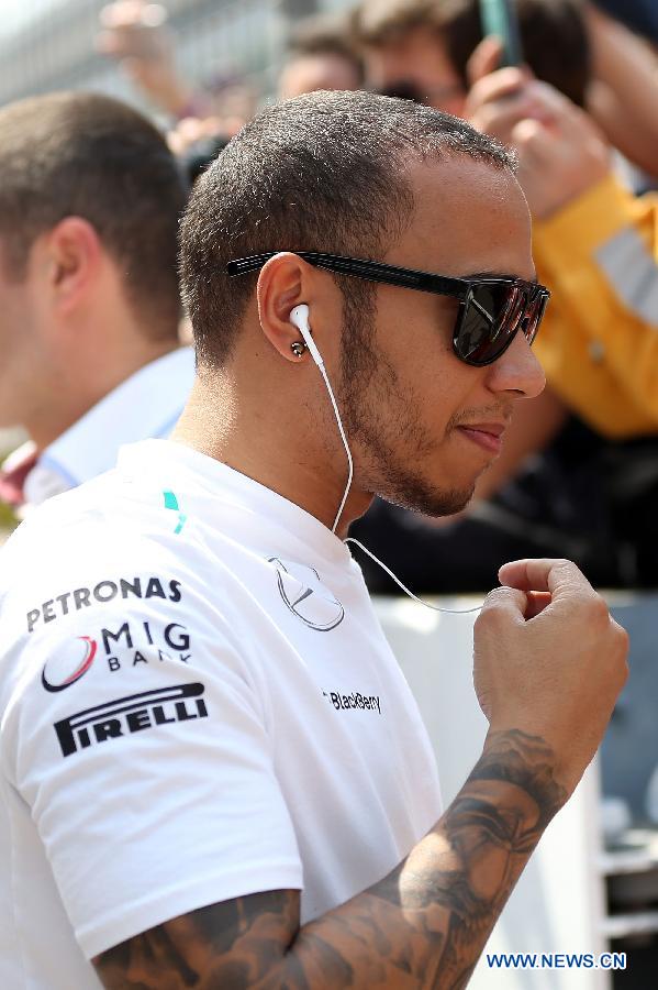 Mercedes driver Lewis Hamilton of Britain reacts after the drivers parade prior to the start of the Chinese F1 Grand Prix at the Shanghai International circuit, in Shanghai, east China, on April 14, 2013. (Xinhua/Li Ming)