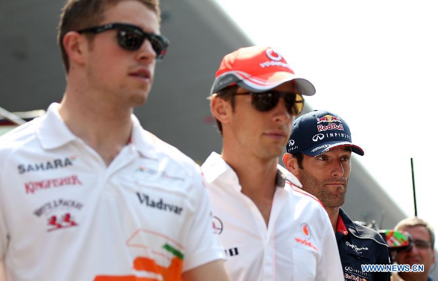 Red Bull driver Mark Webber (R) of Australia reacts after the drivers parade prior to the start of the Chinese F1 Grand Prix at the Shanghai International circuit, in Shanghai, east China, on April 14, 2013. (Xinhua/Li Ming)