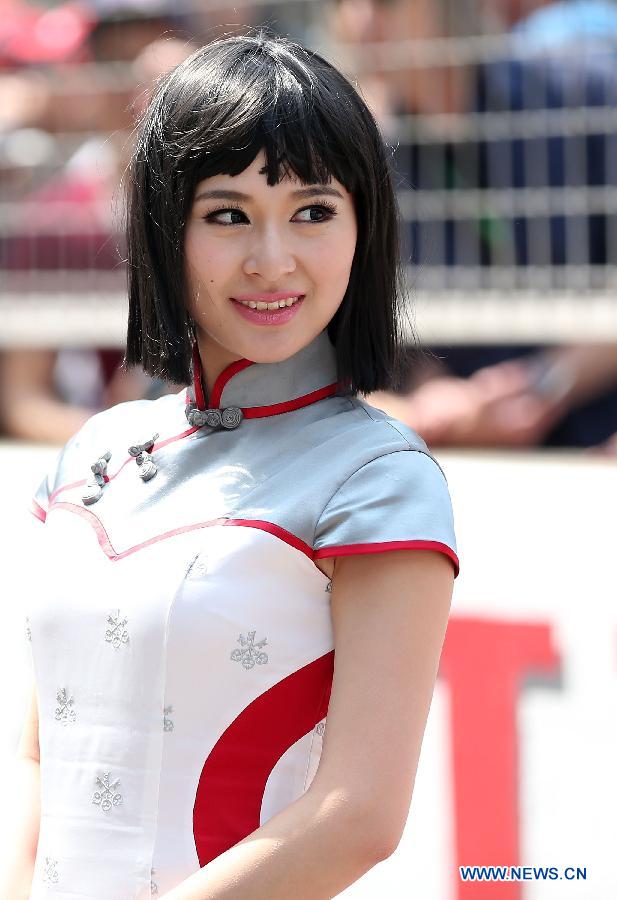 A model smiles during the drivers parade prior to the start of the Chinese F1 Grand Prix at the Shanghai International circuit, in Shanghai, east China, on April 14, 2013. (Xinhua/Li Ming)
