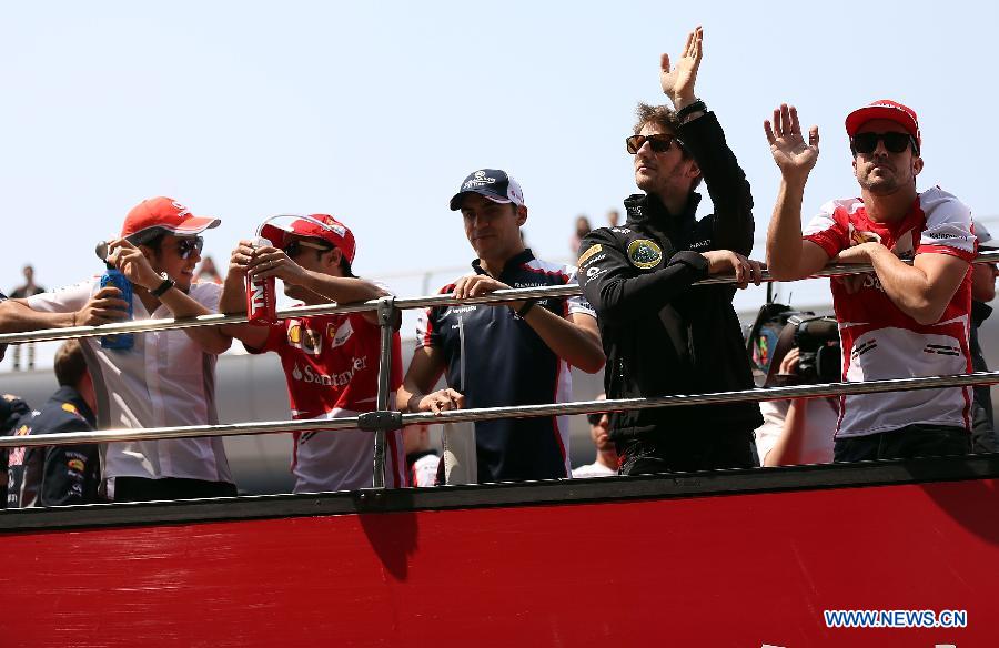 Lotus driver Romain Grosjean of France (2nd, R) and Ferrari driver Fernando Alonso (1st, R) of Spain take part in the drivers parade prior to the start of the Chinese F1 Grand Prix at the Shanghai International circuit, in Shanghai, east China, on April 14, 2013. (Xinhua/Li Ming)