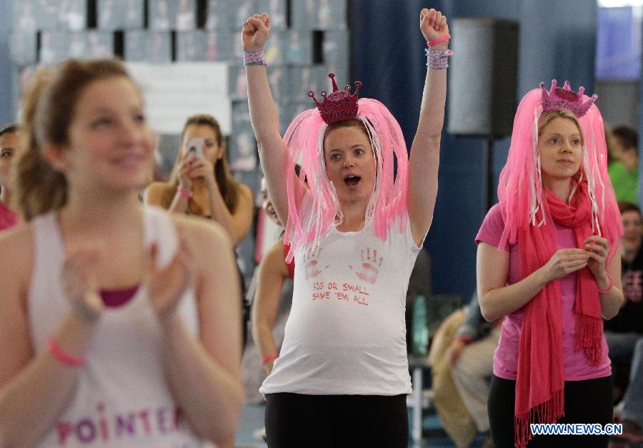 A participant reacts at a marathon exercise fund raising event at the Richmond Oval in Richmond, Canada, on April 13, 2013. Over 300 women take part in a marathon seven-hour dance at the Bust a Move event to raise fund for BC Cancer Foundation in order to help fighting against the breast cancer. (Xinhua/Liang Sen)