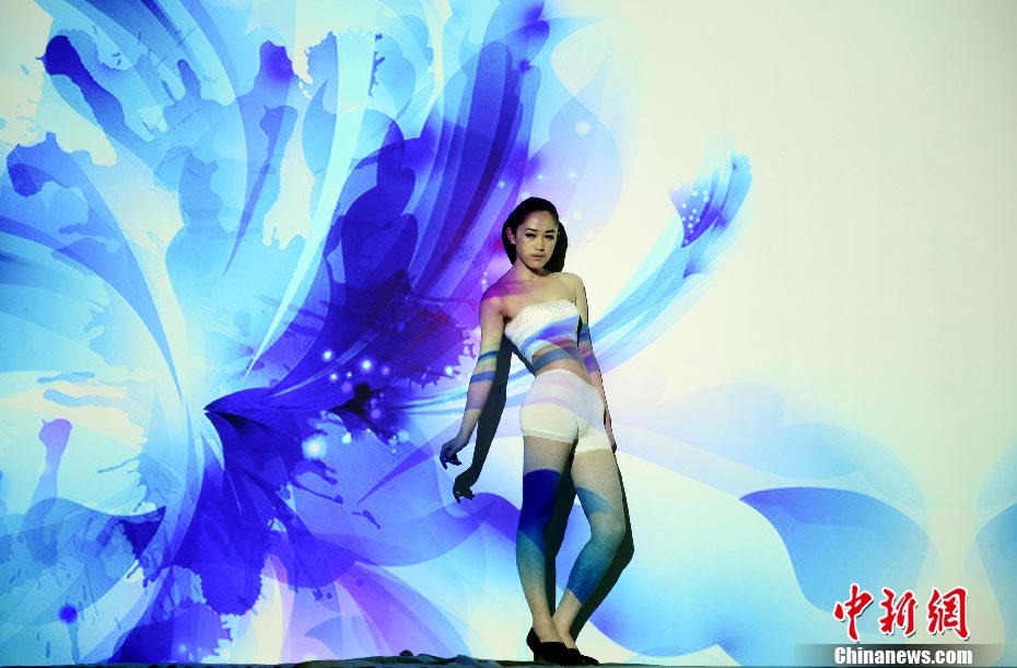 A light and shadow "body painting" show is held in Taiyuan, N China's Shanxi Province, April 13, 2013. Colorful light and shadow created incredible paintings on human bodies, attracting photography fans to a beautiful art world. (chinanews.com/Wei Liang)