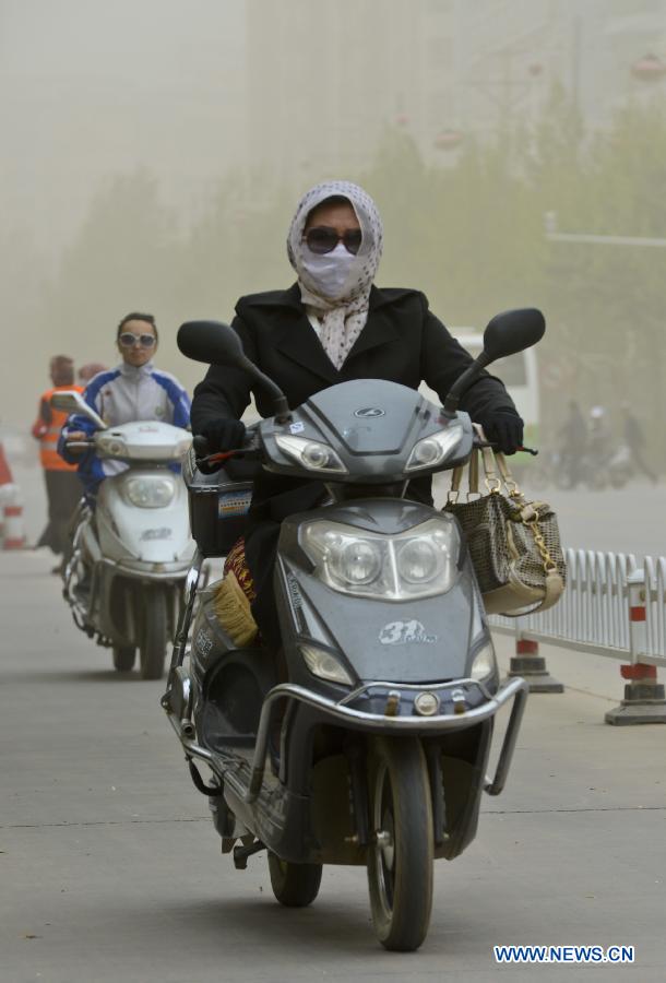A citizen wears a mask while driving amid floating dust and sand storm in Kashgar, northwest China's Xinjiang Uygur Autonomous Region, April 16, 2013. Gales with dust began to hit Kashgar on Tuesday and will last for four days, according to meteorological authority forecast. (Xinhua/Zhao Ge) 