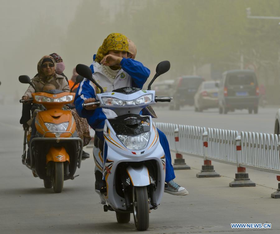 People ride amid floating dust and sand storm in Kashgar, northwest China's Xinjiang Uygur Autonomous Region, April 16, 2013. Gales with dust began to hit Kashgar on Tuesday and will last for four days, according to meteorological authority forecast. (Xinhua/Zhao Ge) 