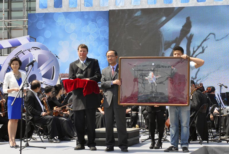 Weta Workshop founder, five-time Academy Award winner Sir Richard Taylor, exchanges gifts with film festival organizers at the opening ceremony of "The Best in Wo-Film Carnival," in Beijing, April 16, 2013. The carnival is open to the public from April 16-23 during the 3rd Beijing International Film Festival. The carnival is a large-scale public cultural activity integrating film cultural entertainment and interactive experience, as well as tourism and leisure. (China.org.cn)