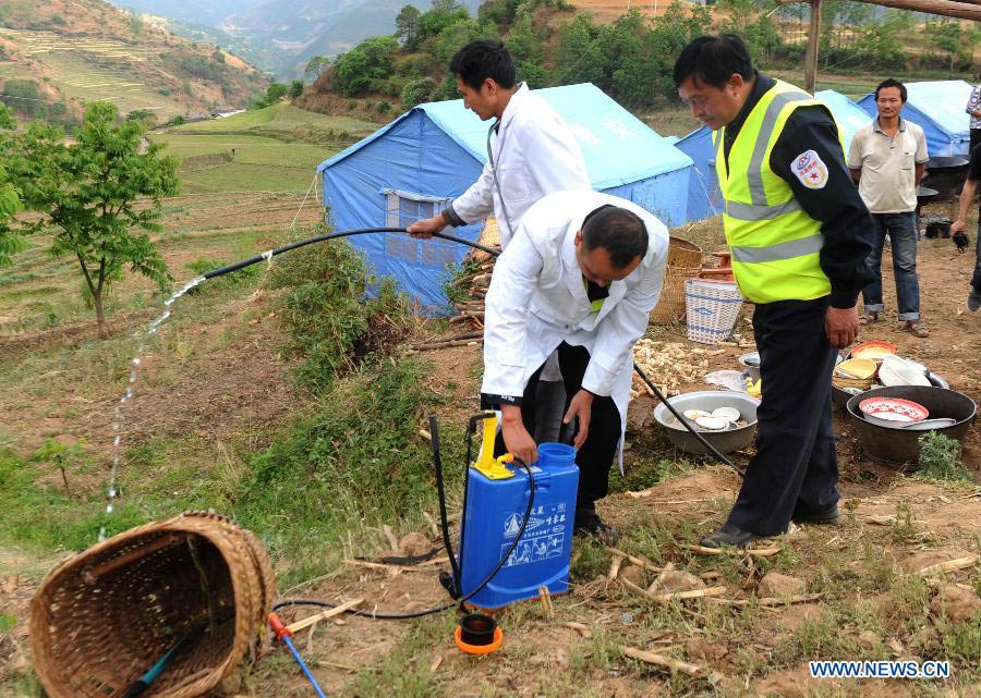 Disease control personnel work at a settlement site at Changyi Village of Liantie Township in Eryuan County under Dali Bai Autonomous Prefecture, southwest China's Yunnan Province , April 17, 2013. A 5-magnitude earthquake jolting Dali Wednesday morning has affected 123,000 people. (Xinhua/Chen Haining)