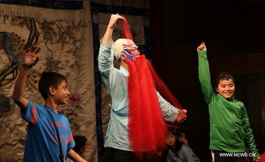Two boys learn Peking Opera performance at the Temple Theatre Beijing Opera House in Beijing, capital of China, April 18, 2013. Students from an international school in Beijing participated in a public education activity named "the charm of Sheng, Dan, Jing, Chou in Peking Opera" on Thursday here. "Sheng","Dan","Jing" and "Chou" refer to different roles in Peking Opera. (Xinhua/Pan Siwei)