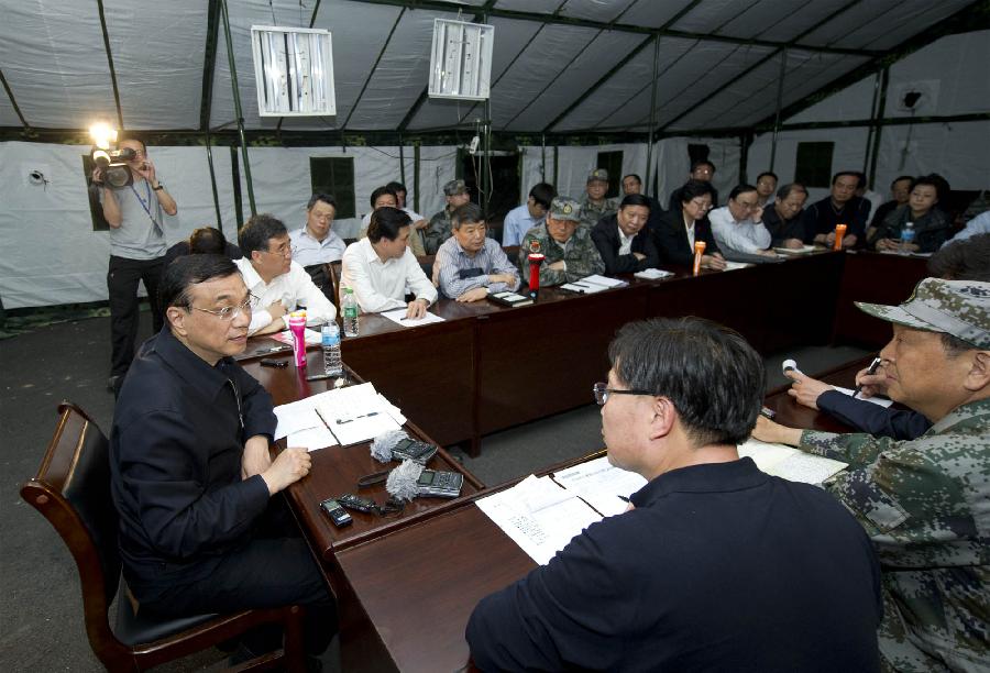 Chinese Premier Li Keqiang (L) presides over a meeting on rescue operations in the quake-hit Lushan County, southwest China's Sichuan Province, April 20, 2013. Li Keqiang arrived in Lushan Saturday afternoon to deploy quake relief work. (Xinhua/Huang Jingwen)