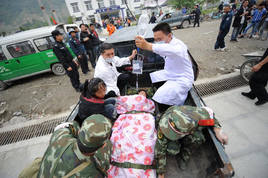 Rescuers transfer an injured person in Lingguan Town of Baoxing County in Ya'an City, southwest China's Sichuan Province, April 21, 2013. A 7.0-magnitude earthquake hit Lushan County of Sichuan Province on Saturday morning, leaving 26 people dead and 2,500 others injured, including 30 in critical condition, in neighboring Baoxing County, county chief Ma Jun said. (Xinhua/Xue Yubin) 