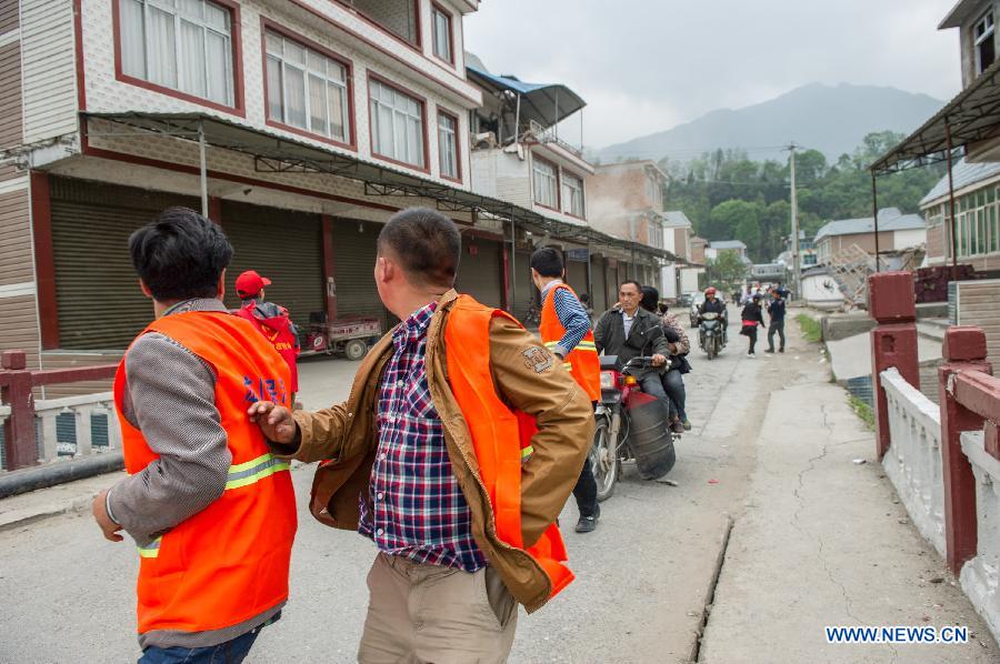 Rescuers run when an aftershock occurs in quake-hit Lushan County in Ya'an City, southwest China's Sichuan Province, April 21, 2013. A 7.0-magnitude earthquake jolted Lushan County on April 20 morning. Aftershocks continued to rock the region. (Xinhua/Chen Cheng)