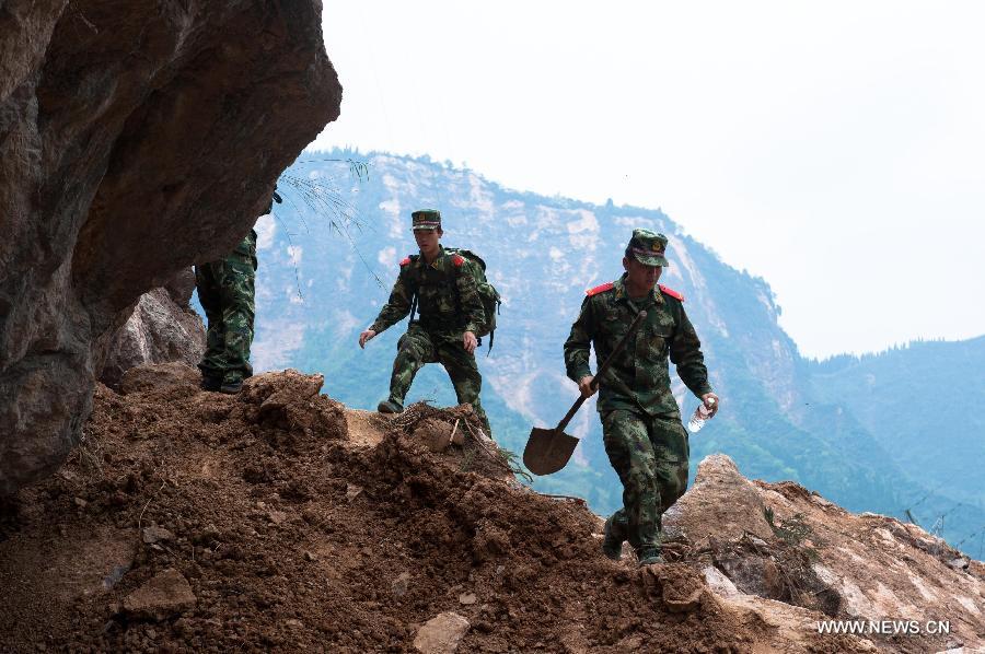 Soldiers run through a landslide area in severely-hit Baosheng Town of Lushan County in Ya'an City, southwest China's Sichuan Province, April 21, 2013. A 7.0-magnitude earthquake jolted Lushan County on April 20. (Xinhua/Liu Jinhai) 