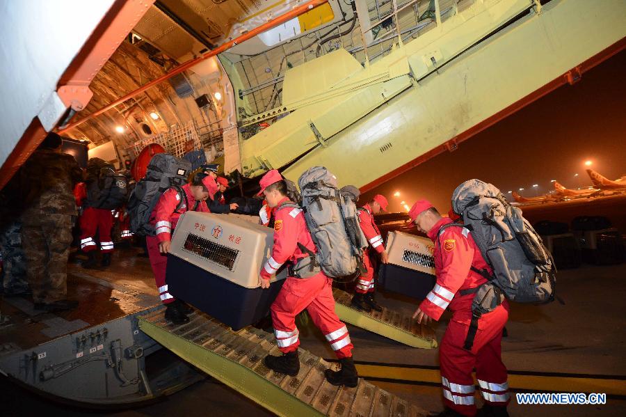 Members of China International Search and Rescue Team (CISAR) carry relief materials to an aircraft which is about to fly to the earth-quake region, at Nanyuan Airport in Beijing, capital of China, April 20, 2013. A total of 140 rescuers and 12 sniffer dogs flied to the earthquake-hit Lushan County, southwest China's Sichuan Province, Saturday night to conduct rescue work. (Xinhua/Yu Hongchun)