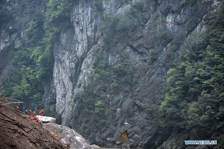 Rescuers try to pass through a road blocked due to the landslide in the quake-hit Baosheng Township, Lushan County, southwest China's Sichuan Province, April 21, 2013. Baosheng Township is another seriously affected area in Lushan. Search and rescue work continued here Sunday, and the work for restoring roads and communications are conducted in the pipelines. (Xinhua/Fei Maohua)