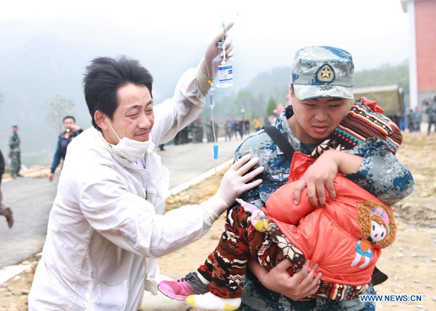 Rescuers transfer an injured child in quake-hit Lushan County, southwest China's Sichuan Province, April 21, 2013. A 7.0-magnitude quake jolted Lushan County of Ya'an City on Saturday morning. (Xinhua/Gao Xiaowen) 