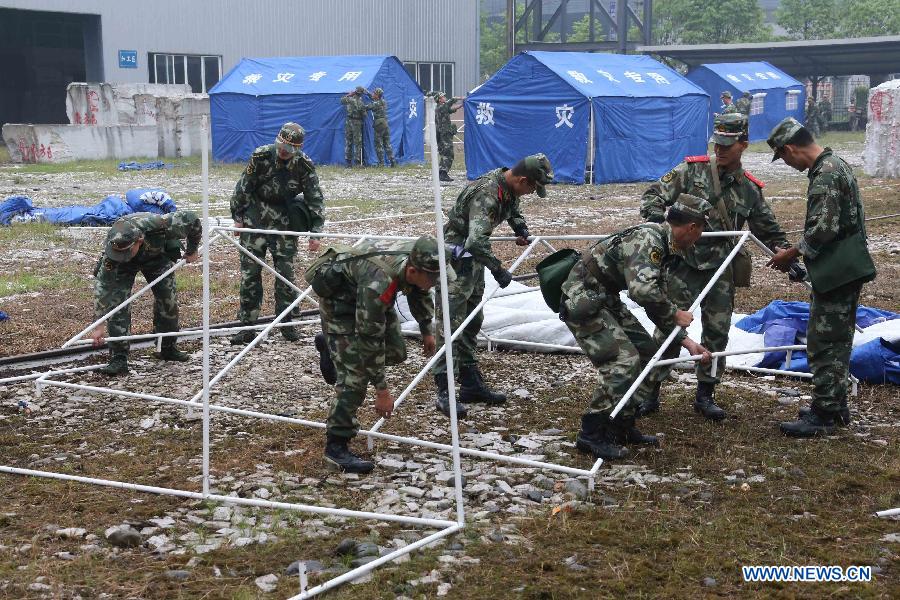 Rescuers put up tents at a temporary settlement for quake-affected people in Lingguan Township of Baoxing County, Ya'an City, southwest China's Sichuan Province, April 22, 2013. A 7.0-magnitude earthquake jolted Lushan County of Ya'an City on Saturday morning. (Xinhua/Wang Jianmin)