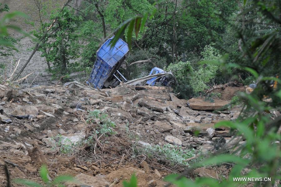 A truck is buried in the landslide in Qinggangpo Township of Sinan County, southwest China's Guizhou Province, April 23, 2013. Nine people died, two were injured and another two were missing following a landslide that occurred at 10:42 p.m on Monday when construction workers were repairing a road damaged by a previous landslide in Sinan County. The rescue operation is underway. (Xinhua/Tao Liang) 