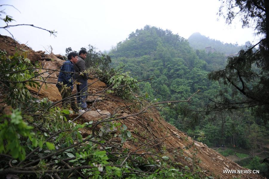 Local residents gather at the accident site of a landslide in Qinggangpo Township of Sinan County, southwest China's Guizhou Province, April 23, 2013. Nine people died, two were injured and another two were missing following a landslide that occurred at 10:42 p.m on Monday when construction workers were repairing a road damaged by a previous landslide in Sinan County. The rescue operation is underway. (Xinhua/Tao Liang) 