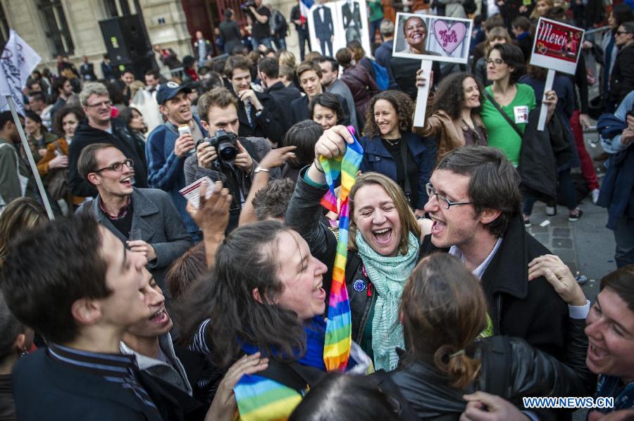 Supporters celebrate after France's legislators give the green light to same-sex couples to marry and adopt children in Paris, April 23, 2013. As the ruling Socialist Party (PS) enjoys an absolute majority at the National Assembly where 331 legislators voted for the bill and 225 voted against, it successfully paved the way for France to join dozens of other countries, mostly in Europe, to allow same-sex unions and adoption.(Xinhua/Etienne Laurent)