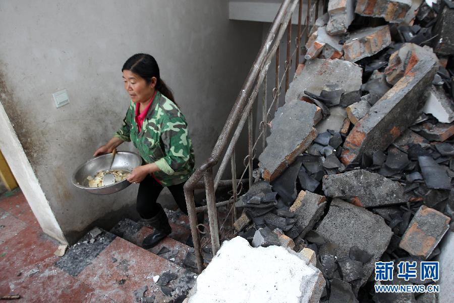 Yue Yan's mother prepares dishes at their house, which has been seriously damaged by the 7.0-magnitude earthquake, April 22, 2013.(Zhang Xiaoli/Xinhua) 