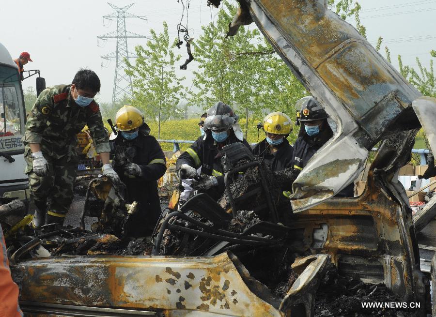 Rescuers work at the accident site after a passenger vehicle rear-ended a truck at an expressway in Yancheng City, east China's Jiangsu Province, April 24, 2013. A fire broke out after the rear-end collision occurred, killing all the 8 people in the passenger vehicle.(Xinhua/Zhou Chenyang) 
