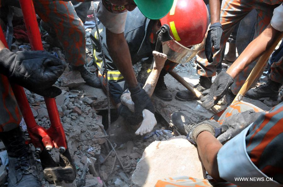 Rescuers remove a body from the collapsed building in Savar, Bangladesh, April 24, 2013. At least 70 people were killed and over six hundred injured after an eight-storey building in Savar on the outskirts of the Bangladeshi capital Dhaka collapsed on Wednesday morning. (Xinhua/Shariful Islam)  
