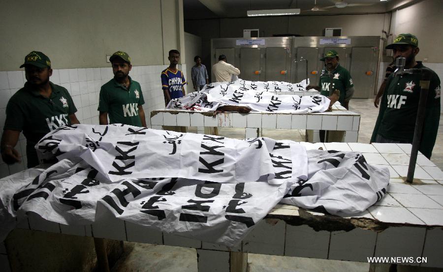 Rescuers gathered around the bodies at a hospital in southern Pakistani port city of Karachi on April 25, 2013. At least five people were killed and 14 others injured in a bomb blast that hit a political gathering in Pakistan's southern port city of Karachi, local media and police said. (Xinhua/Arshad) 