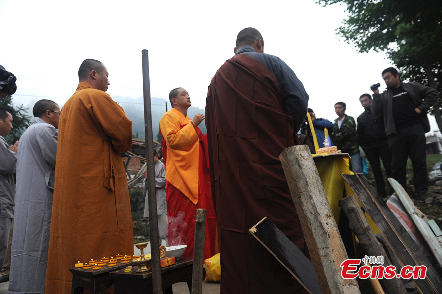 Monks of the Shaolin Temple pray for the victims of the 7.0-magnitude earthquake in Lushan County, Ya'an, Southwest China's Sichuan Province, April 26, 2013. On the early morning of April 23, nine monks and staff member from the Songshan Shaolin Temple came to the disaster area of Lushan. They bring large quantities of traditional Chinese medicine products made by Shaolin pharmacy and two equipment vehicles for Western medicine treatment. （Photo: CNS/Zhang Lang）