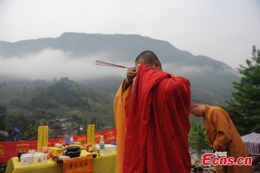 A monk of the Shaolin Temple prays for the victims of the 7.0-magnitude earthquake in Lushan County, Ya'an, Southwest China's Sichuan Province, April 26, 2013. On the early morning of April 23, nine monks and staff member from the Songshan Shaolin Temple came to the disaster area of Lushan. They bring large quantities of traditional Chinese medicine products made by Shaolin pharmacy and two equipment vehicles for Western medicine treatment. （Photo: CNS/Zhang Lang）