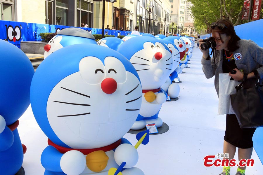A visitor takes photos for Doraemon, a robot cat in a Japanese animation series, at Xintiandi in Shanghai, April 26, 2013. An exhibition featuring 100 Doraemons with 100 different gadgets and machines it used in the series is being held at Xintiandi until June 16. It is the largest exhibition featuring Doraemon on the Chinese mainland. (CNS/Pan Suofei) 
