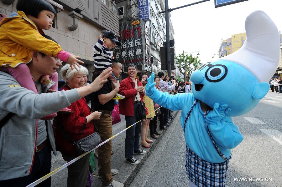 An actor dressing as the Smurf interacts with spectators in a cartoon and animation floats parade during the ninth China International Cartoon & Animation Festival in Hangzhou, capital of east China's Zhejiang Province, April 28, 2013. (Xinhua/Ju Huanzong) 