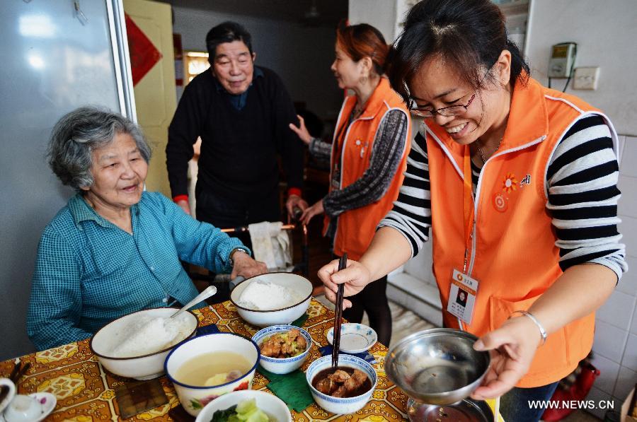 Volunteers deliver meals to the apartment of an old couple in Gulou District of Fuzhou, capital of southeast China's Fujian Province, April 28, 2013. A total of 435 community service centers have been set up in Fuzhou since 2008 to provide daily care and entertainment activities for senior citizens. (Xinhua/Zhang Guojun)  