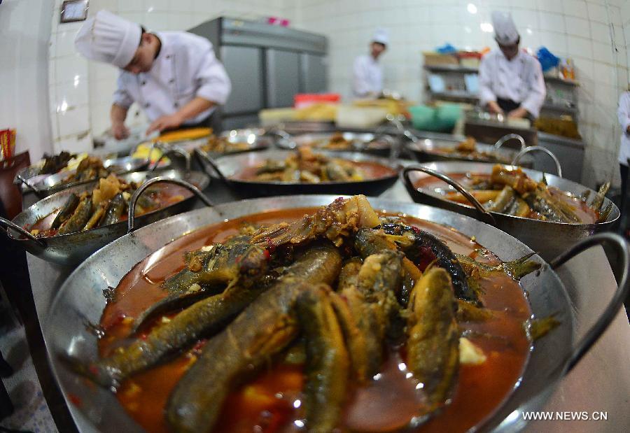 Chefs make dishes in a restaurant in Sanhe Town of Feixi County, east China's Anhui Province, April 24, 2013. The Sanhe Ancient Town, which has a history of more than 2,500 years, is a typical "ancient town full of rivers and lakes, together with small bridges, flowing water and locla dwellings." (Xinhua/Wang Song)
