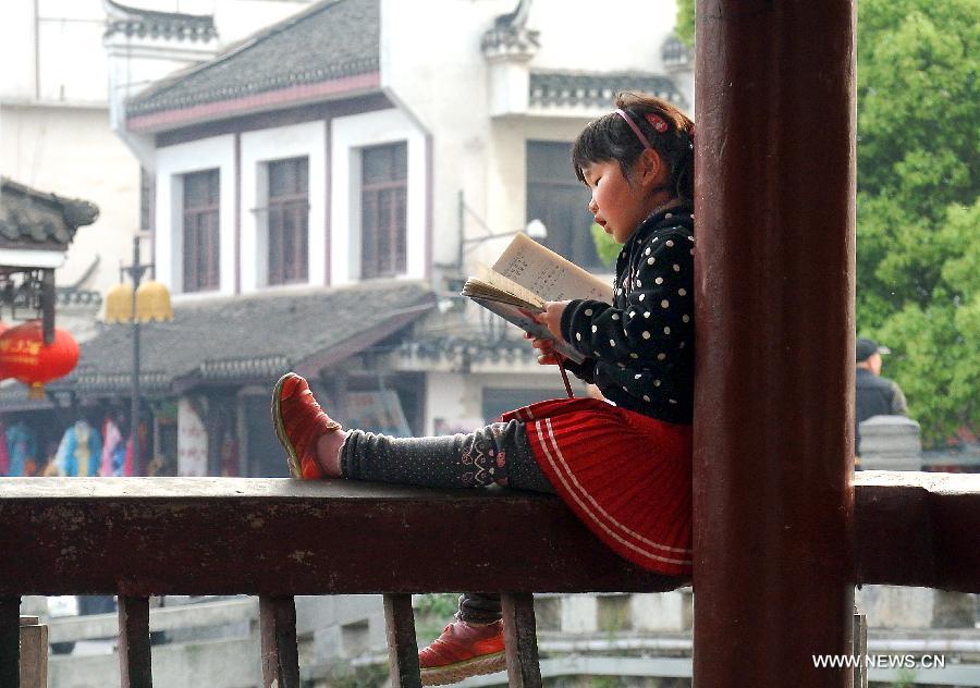 A girl reads a book in a pavilion in Sanhe Town of Feixi County, east China's Anhui Province, April 25, 2013. The Sanhe Ancient Town, which has a history of more than 2,500 years, is a typical "ancient town full of rivers and lakes, together with small bridges, flowing water and local dwellings." (Xinhua/Wang Song)