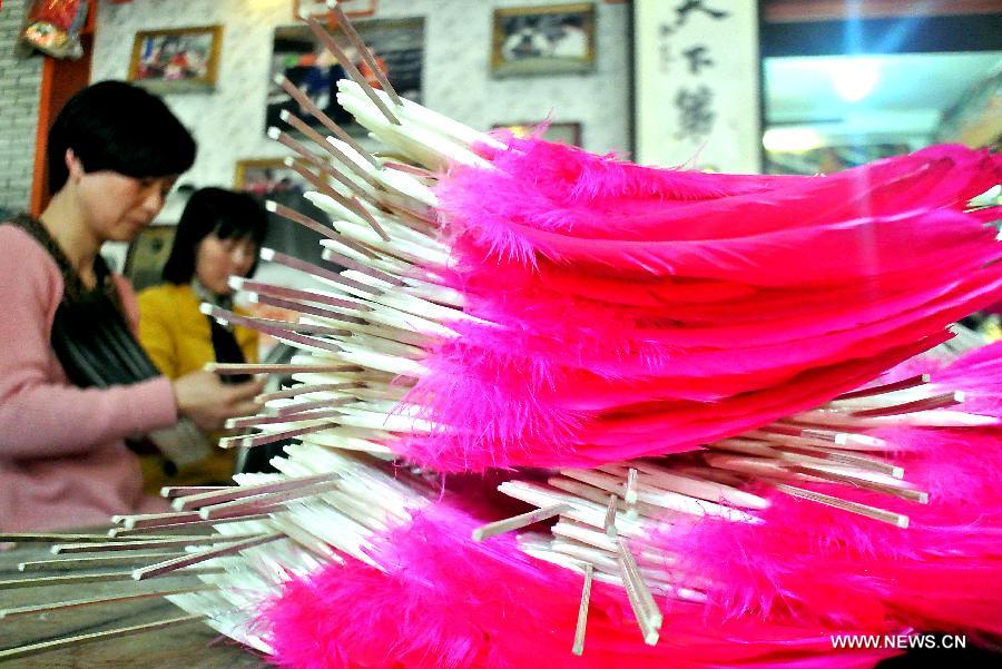 Workers make feather fans in a traditional way at a workshop in Sanhe Town of Feixi County, east China's Anhui Province, April 24, 2013. The Sanhe Ancient Town, which has a history of more than 2,500 years, is a typical "ancient town full of rivers and lakes, together with small bridges, flowing water and local dwellings." (Xinhua/Wang Song)