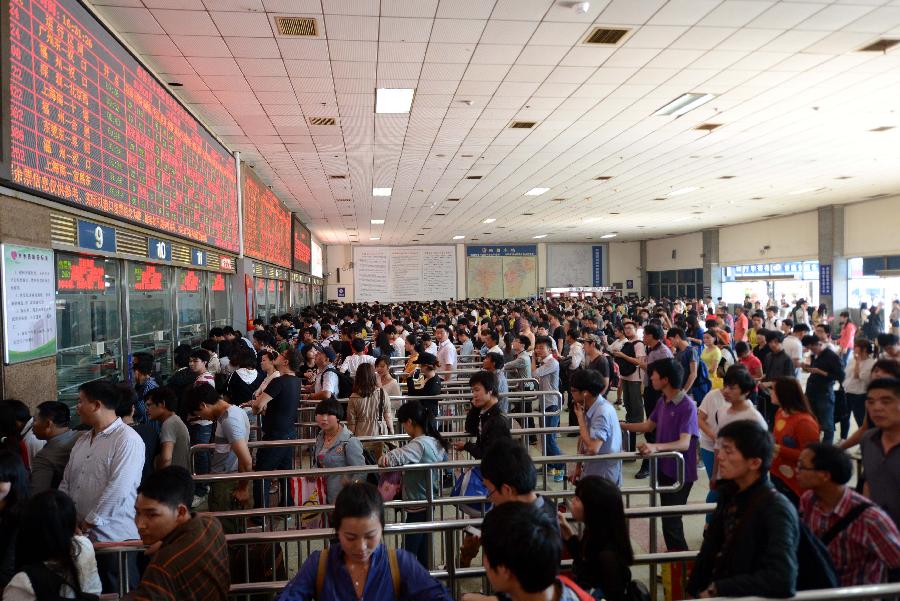 Passengers line up to buy train tickets in Yinchuan Railway Station in Nanchang, capital of east China's Jiangxi Province, April 28, 2013. China sees a travel rush around the country as the three-day May First national holiday comes around the corner. (Xinhua/Zhou Ke)