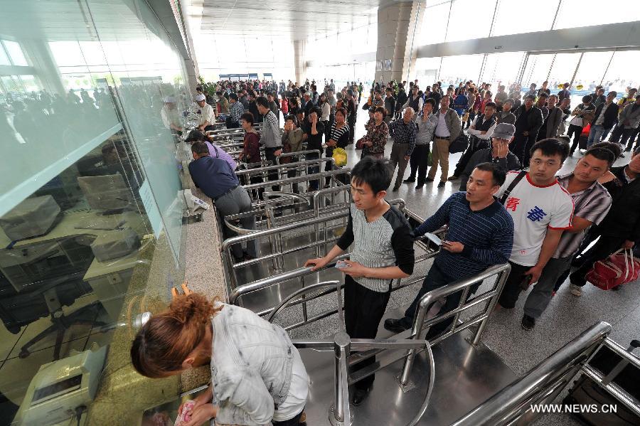 Passengers line up to buy train tickets in Yinchuan Railway Station in Yinchuan, capital of northwest China's Ningxia Hui Autonomous Region, April 28, 2013. China sees a travel rush around the country as the three-day May First national holiday comes around the corner. (Xinhua/Ding Ting)