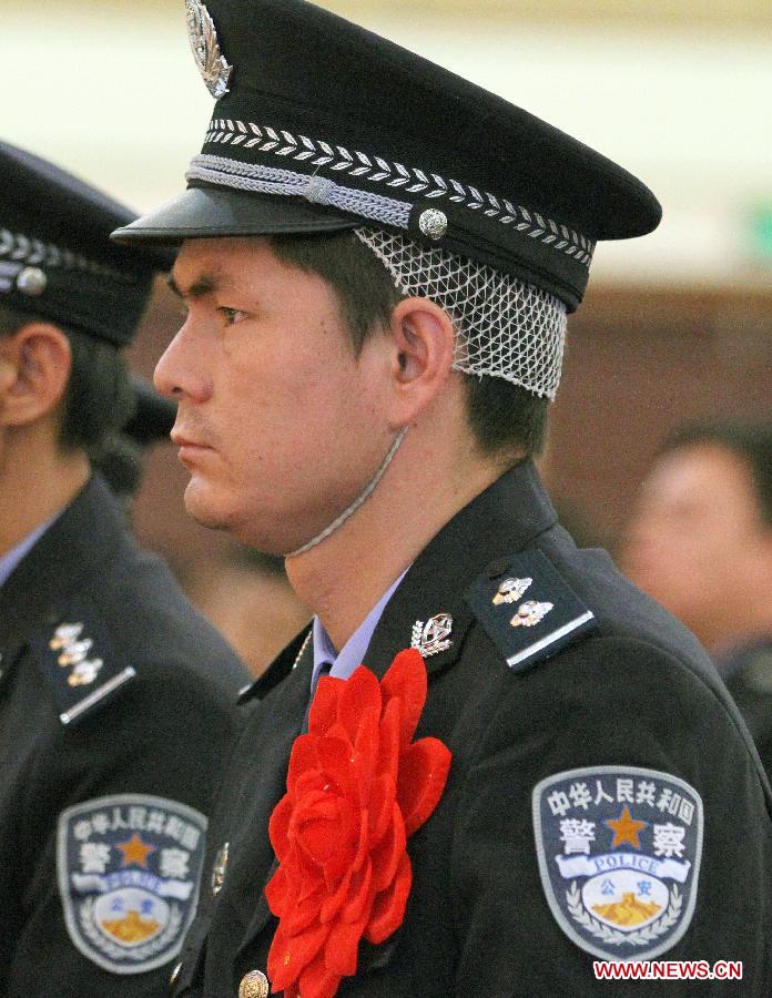 An injured policeman attends a commendation meeting to award the 15 community workers and police officers who died during a terrorist clash on April 23 in Bachu County, Kashgar Prefecture, northwest China's Xinjiang Uygur Autonomous Region, April 29, 2013. The regional Communist Party of China (CPC) committee and government posthumously awarded the 15 individuals each as a "regional anti-terrorist hero," seven of whom were also posthumously awarded as a "regional outstanding CPC member". (Xinhua/Zhang Huawei)