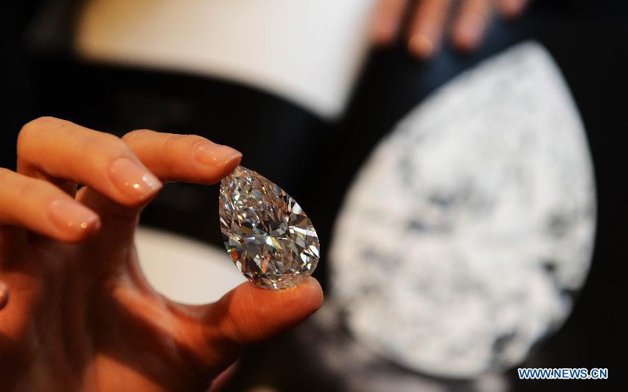 A worker shows the 101.73-carat diamond to the media at the Christie in Geneva, Switzerland, April 30, 2013. Christie will hold spring sale of Jewels auction in Geneva on May 15, 2013. Led by a truly sensational pear-shaped, D colour, flawless diamond of 101.73 carats, the sale will reach to an estimated combined total of 65 million dollars. This Type IIA Flawless gem was found at the Jwaneng mine in Botswana and took 21 months to polish. This gemstone is estimated to be sold at a price between 20 to 30 million dollars and the successful buyer will have the privilege of endowing the diamond a name. (Xinhua/Wang Siwei)