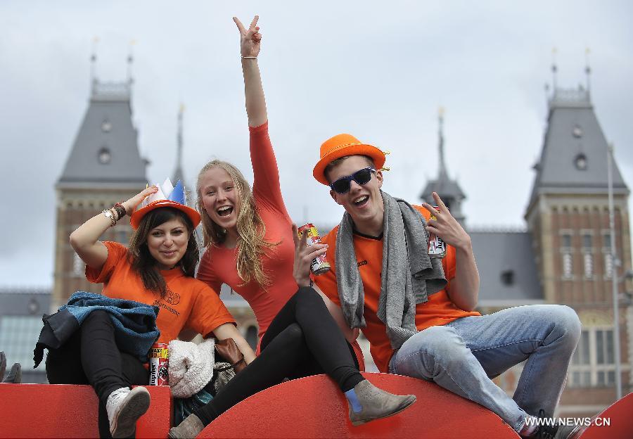 People celebrate the inauguration of the new King of the Netherlands Willem-Alexander in Amsterdam, the Netherlands, April 30, 2013. Following the abdication of Queen Beatrix, the new King of the Netherlands Willem-Alexander was officially inaugurated on Tuesday. (Xinhua/Ye Pingfan)