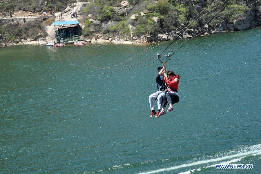 Tourists try cable descent during the three-day May Day holidays at the scenic zone of Qinglong Gorge in Huairou District of Beijing, capital of China, April 30, 2013. (Xinhua/Wang Junfeng)
