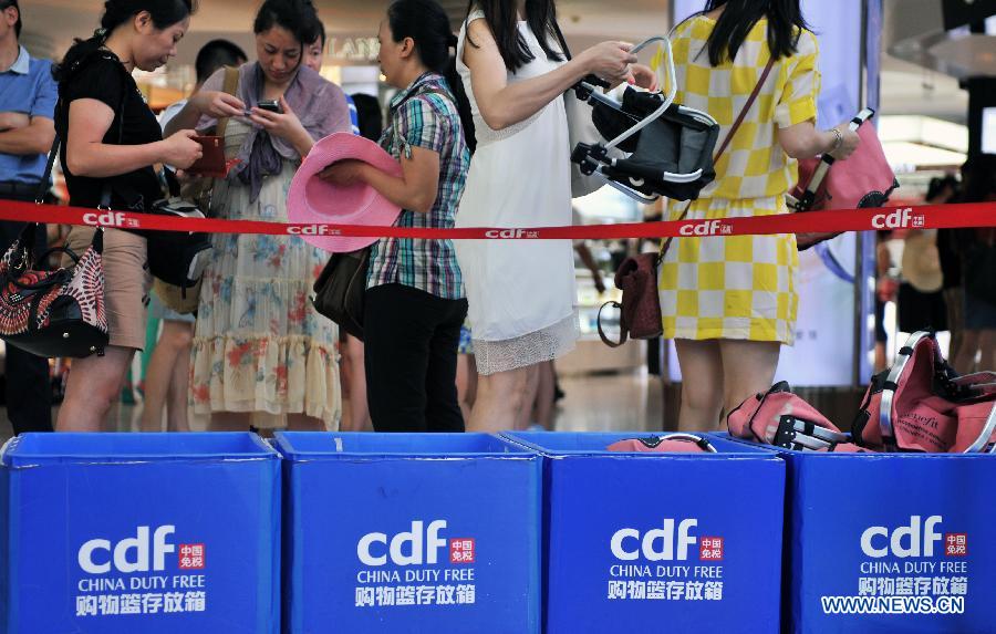 Tourists select goods at a duty-free shop in Sanya, a famous tourist destination in south China's Hainan Province, May 1, 2013. Promotions in the duty-free shop attracted numerous customers during the three-day public holiday for the international workers' day on May 1. Data released by the provincial customs authorities on April 26 showed that 1.94 million visitors have purchased goods worth 4.68 billion yuan (about 752 million U.S. dollars) as of April 20. The offshore duty-free program, put into place in April 2011 on a trial basis, is part of an effort to promote Hainan as an international tourist destination. (Xinhua/Shi Manke)