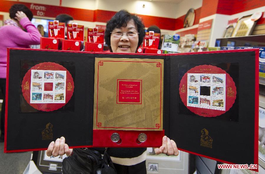 A collector shows a colletion of the Chinatown Gates stamps she bought at a post office in Toronto, Canada, May 1, 2013. Canada Post launched a special series of stamps featuring Chinatown gates located in eight cities across the country on Wednesday to highlight the longstanding heritages of Chinese-Canadians. (Xinhua/Zou Zheng)