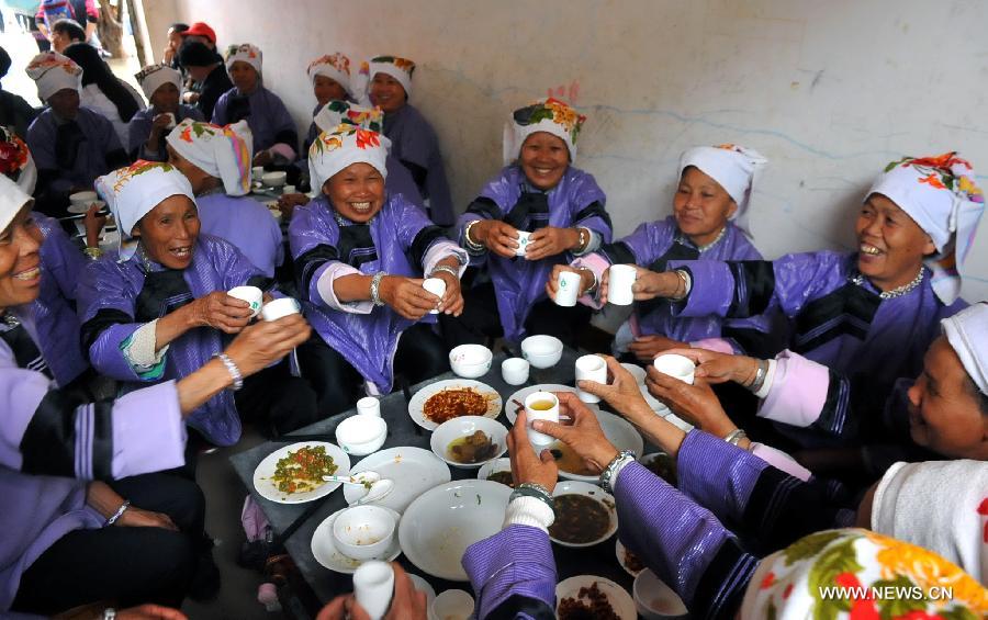Women of Zhuang ethnic group enjoy their meal during the traditional "Huajie Festival" of Zhuang ethnic group, in Guangnan County, southwest China's Yunnan Province, May 2, 2013. (Xinhua/Chen Haining)