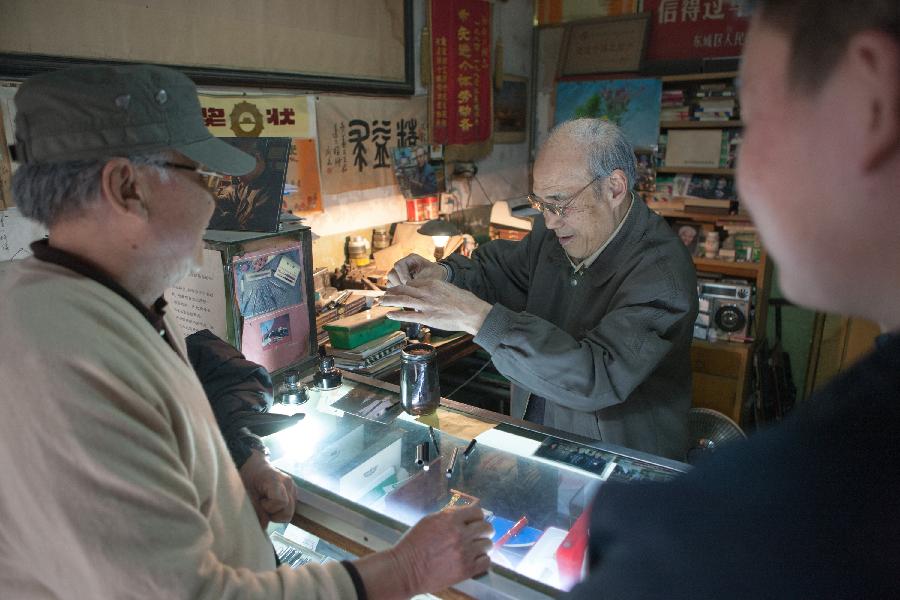 Zhang Guangyi (C) works on a pen with blocked-tip at his shop in Beijing, capital of China, April 26, 2013. (Xinhua/Xu Zijian)